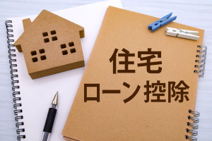 住宅ローン控除と書かれたノートと家のモチーフ