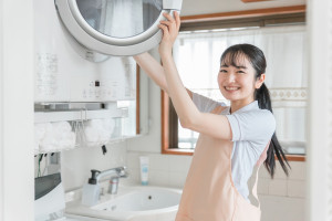 乾燥機から洗濯物を出す女性